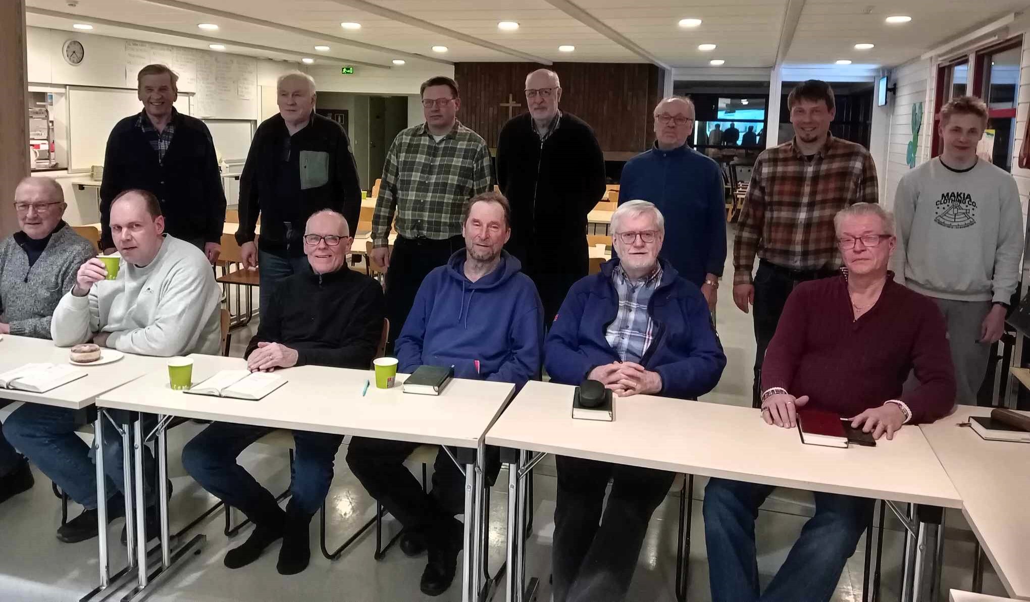 Miesjoukko kokoontunut ristin äärelle.