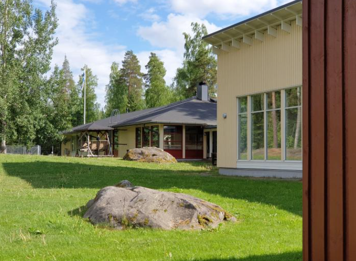 Kaksi leirikeskuksen rakennusta ja nurmikkoa