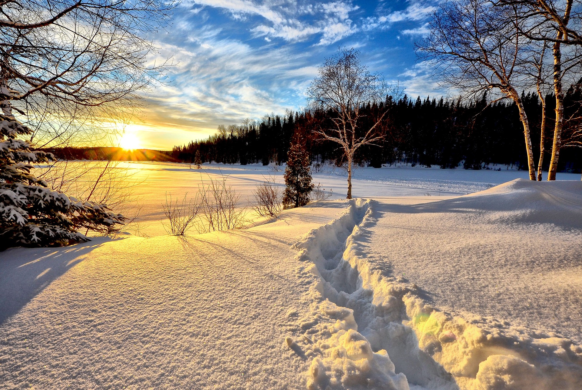 Polku lumessa auringon laskussa.