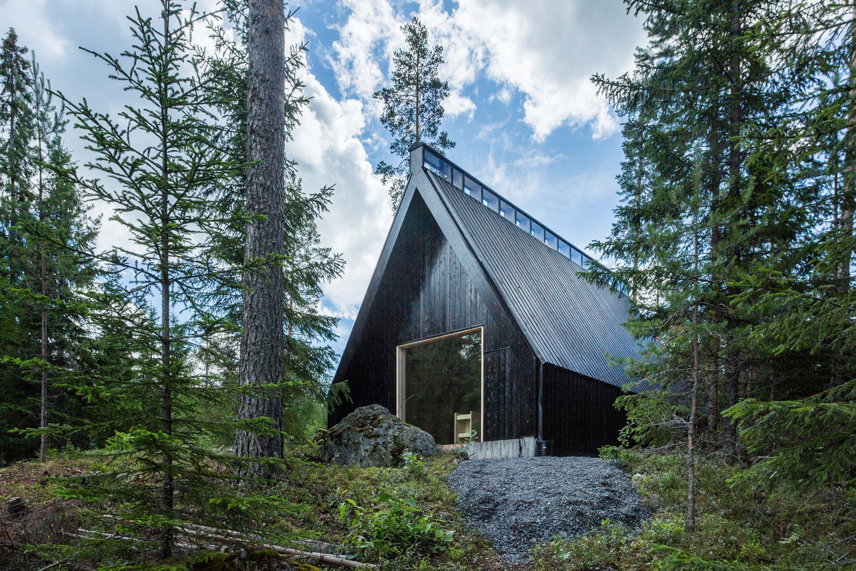Tervajärven metsäkappeli Tummaksi tervattu jyrkkäkattoinen Tervajärven metsäkappeli järven suunnasta katsottuna, päädyssä alttari-ikkuna.