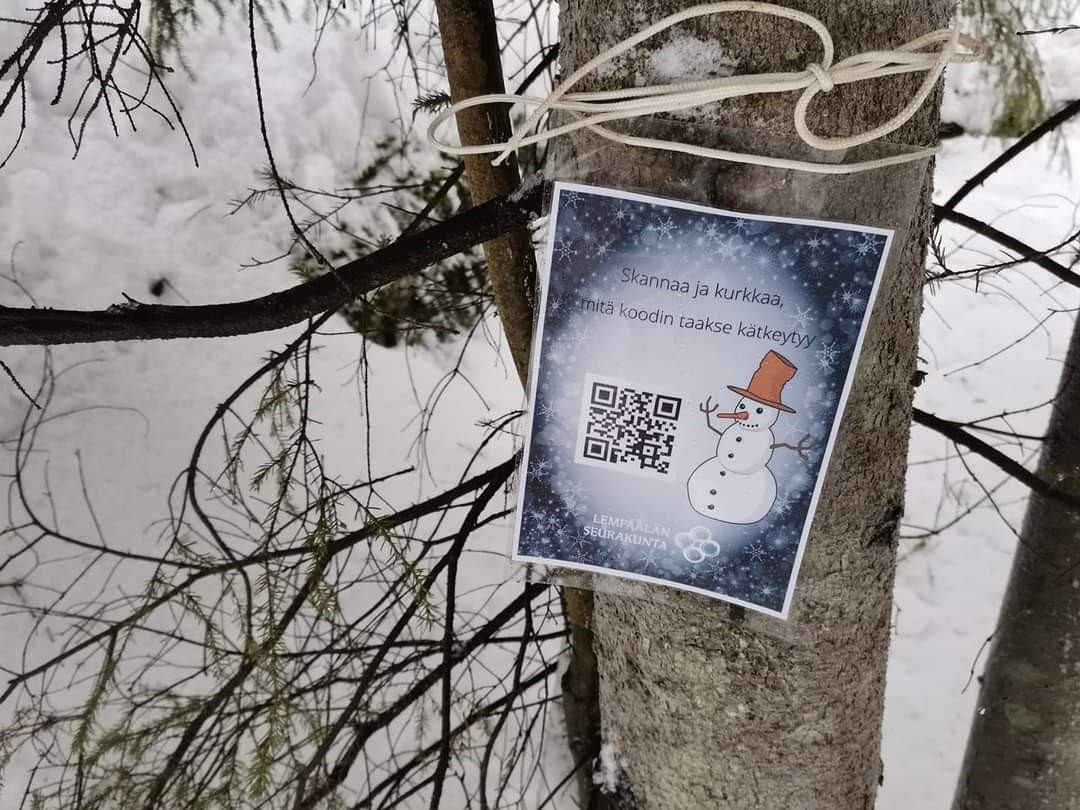 Luontoreitin opaste lumisessa puussa.