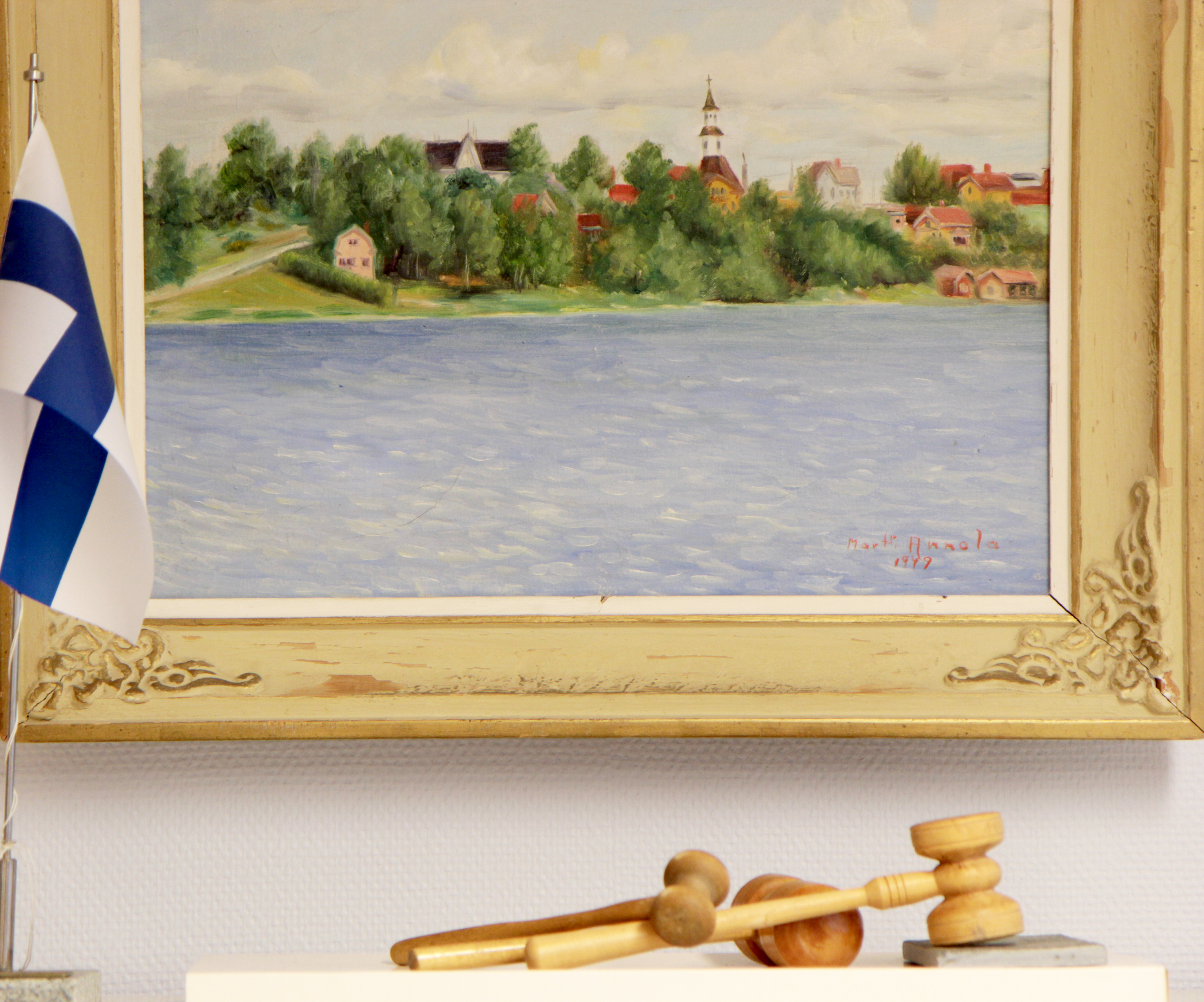 Asetelma, jossa maalaus kirkosta, Suomen lippu sekä nuija