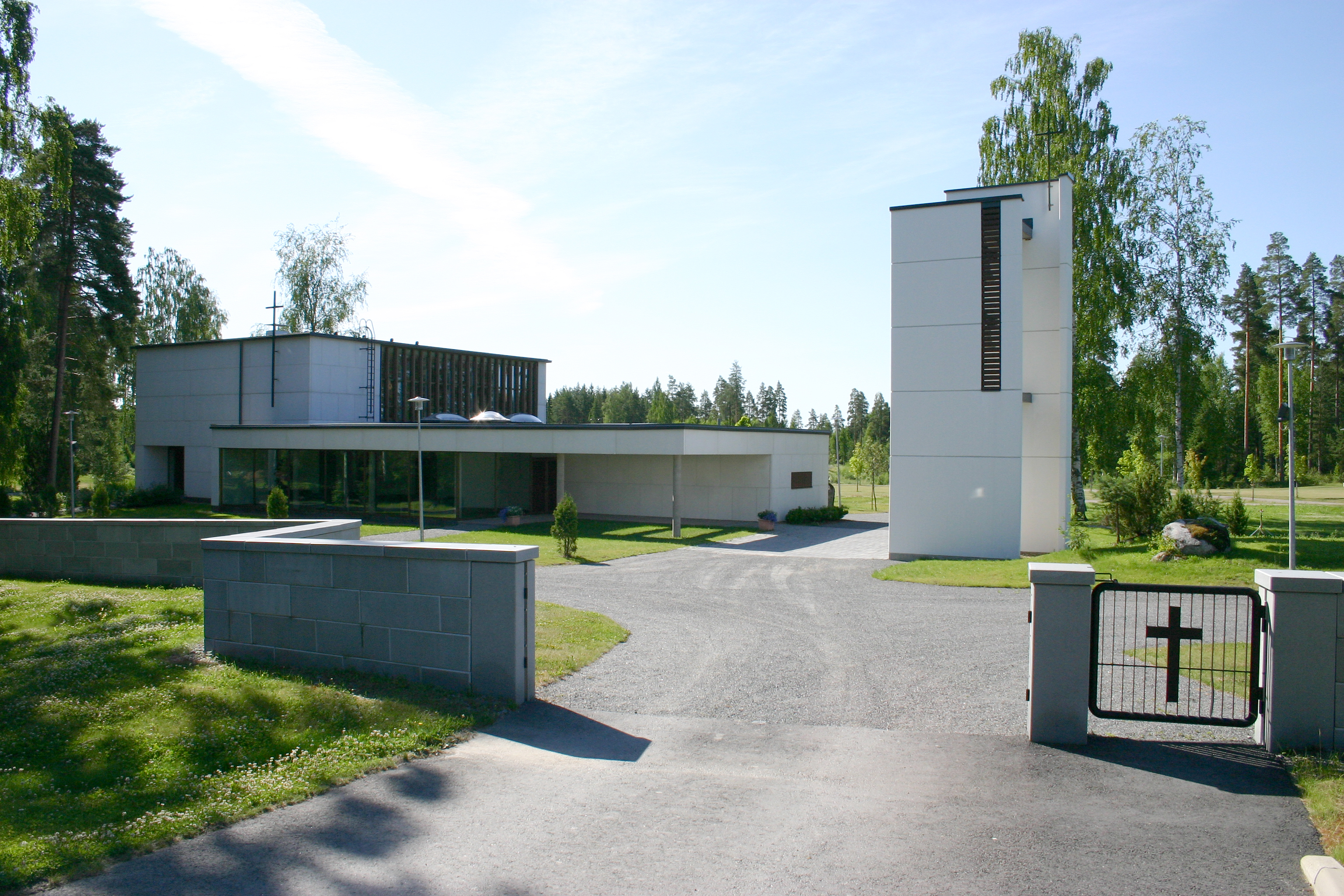 Ristimäen siunauskappeli Ristimäen valkoinen, moderni kappeli ja sen kellotapuli kesällä.