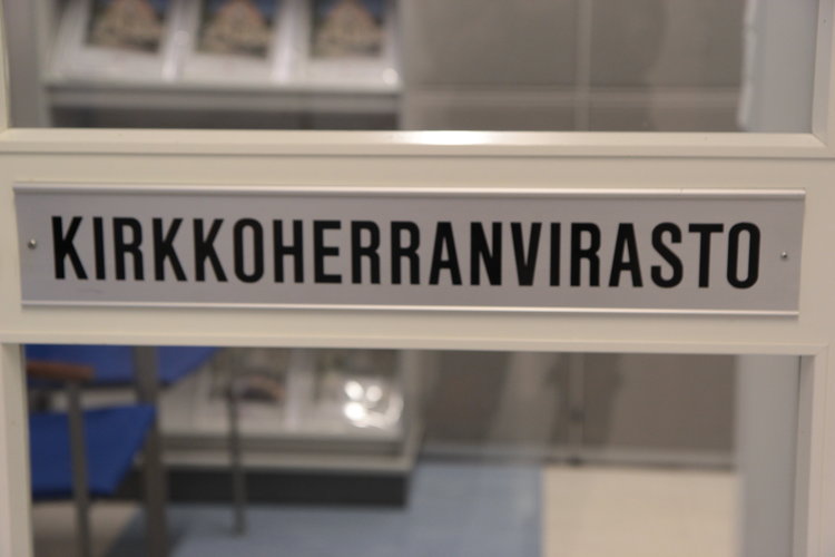 Kirkkoherranviraston kyltti ovessa.