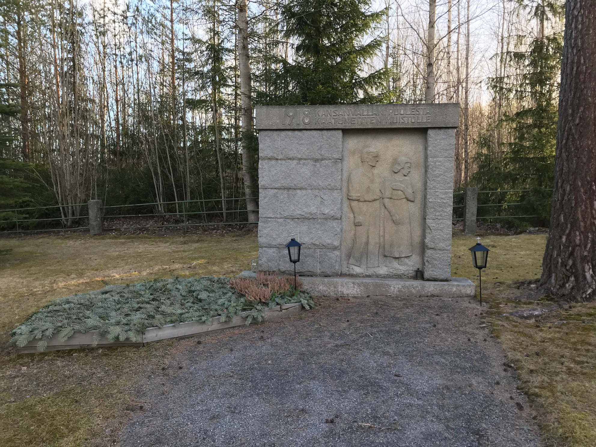 Vakaumuksensa puolesta kaatuneiden muistomerkki Kauniissa luonnossa sijaitsevassa suuressa muistomerkissä sureva nainen ja mies.