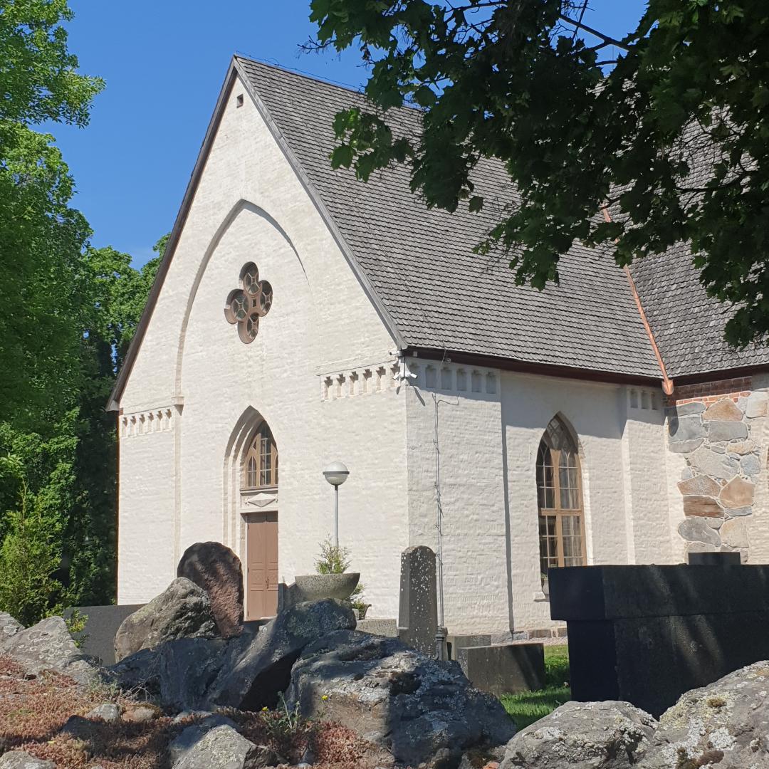 Pyhän Birgitan kirkon valkoiseksi kalkittu eteläinen pääty, edessä vanhaa kivimuuria.  