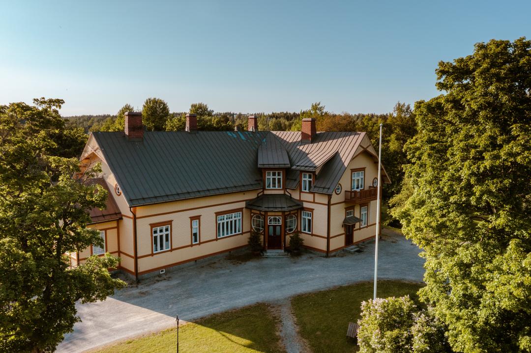 Kesäinen ilmakuva Vanhasta pappilasta pääsisäänkäynnin puolelta.  