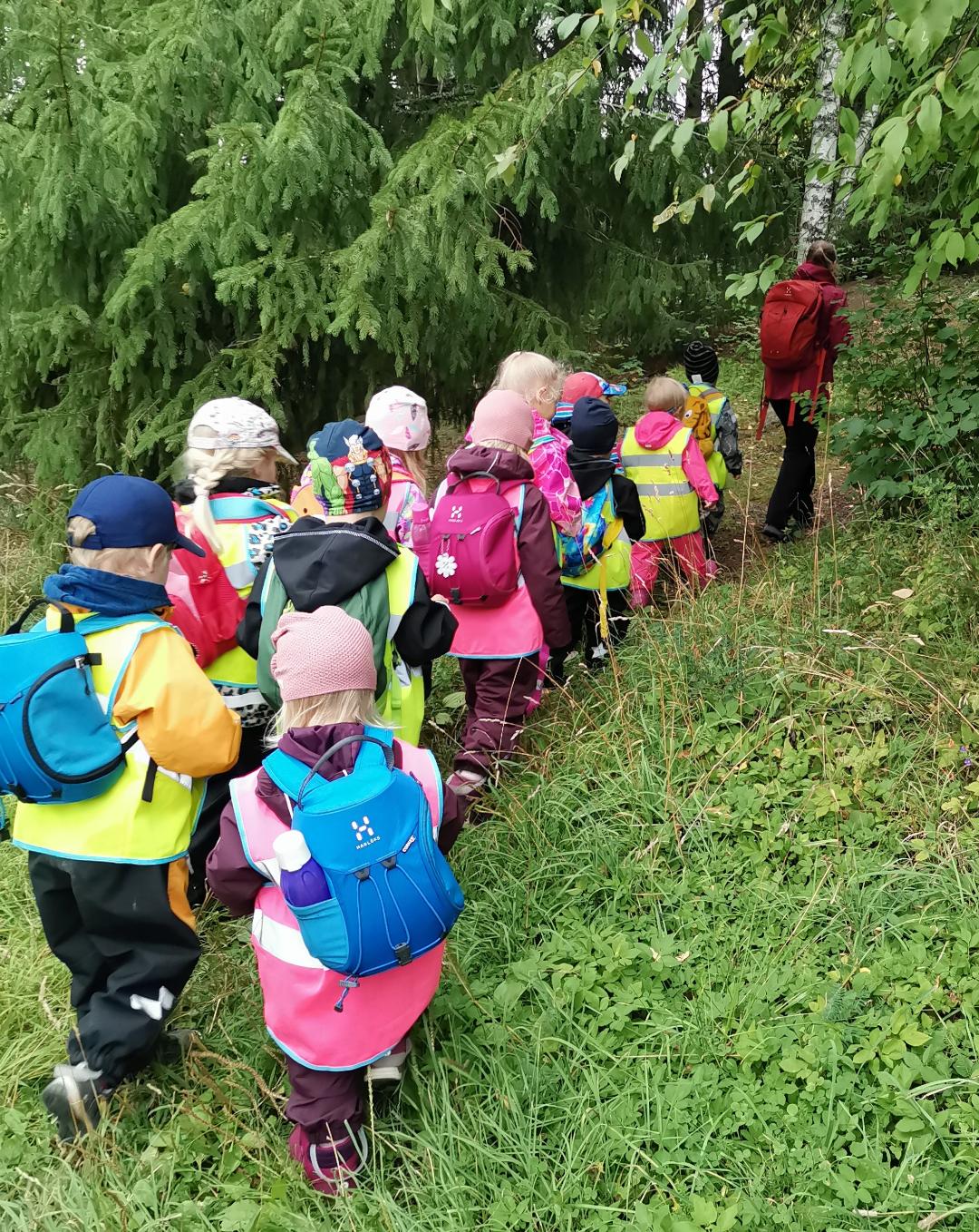 Lapsia menossa metsään reput selässä